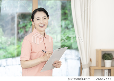Middle-aged female caregiver/care worker Middle-aged female caregiver/care worker 126867337