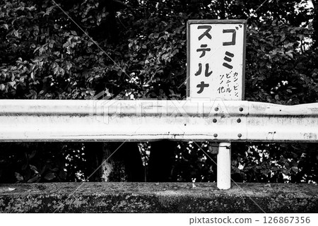 手寫的「請勿亂丟垃圾」標誌和生鏽的護欄（單色） 126867356