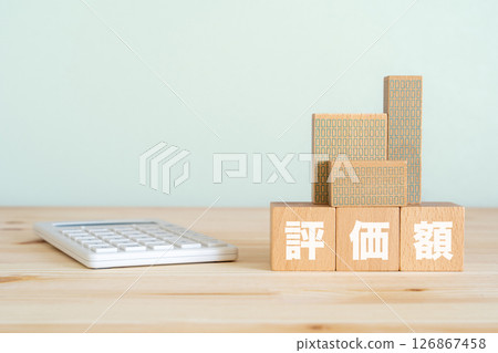 A block with the word "assessed value" written on it, a model of a property, and a calculator 126867458