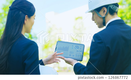 Male and female workers consulting while looking at a tablet Male and female workers consulting while looking at a tablet 126867772