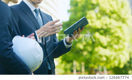 男女員工一邊看平板電腦一邊進行諮詢 126867774