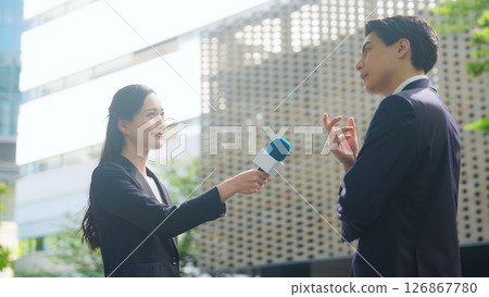 Female reporter doing street interview Female reporter doing street interview 126867780