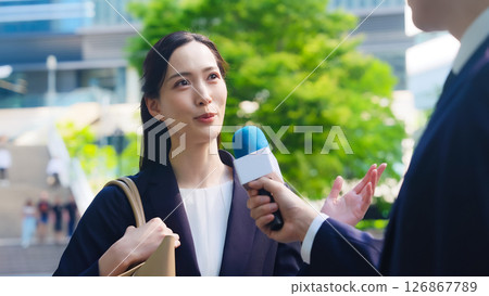 A female business person being interviewed on the street 126867789