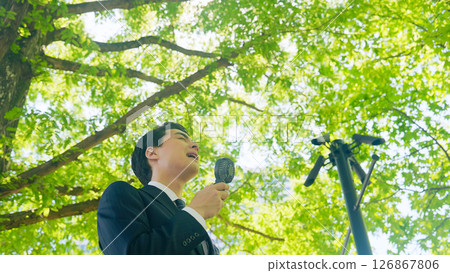 Male business person cooling off with a portable fan Male business person cooling off with a portable fan 126867806