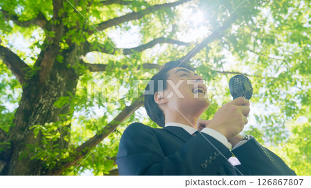 Male business person cooling off with a portable fan Male business person cooling off with a portable fan 126867807