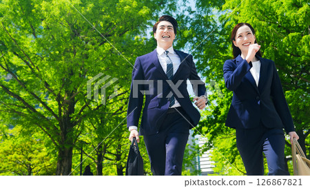 男女商人奔跑在綠樹成蔭的城市中 126867821