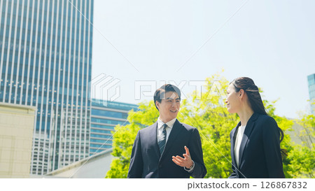 男女商人漫步在綠樹成蔭的城市 126867832