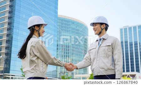 Group of male and female engineers shaking hands at a construction site 126867840