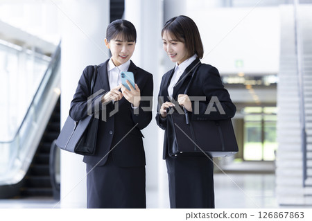 Job hunting: A woman looking at her smartphone 126867863