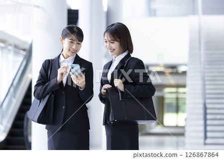 Job hunting: A woman looking at her smartphone Job hunting: A woman looking at her smartphone 126867864