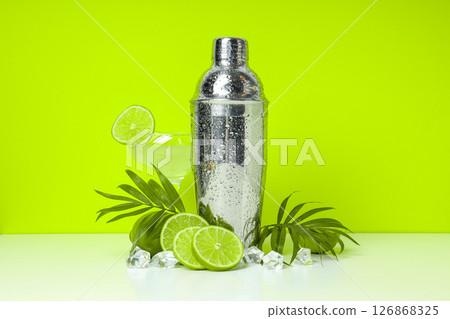 Shaker with fresh lime and glass on light background Shaker with fresh lime and glass on light background 126868325
