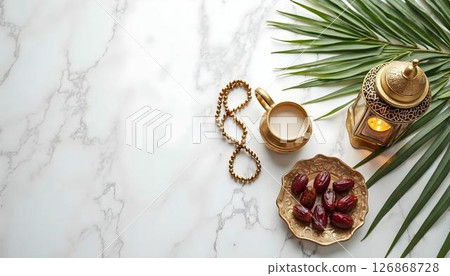 A minimalist arrangement of dates and a teapot on a marble background, perfect for Ramadan and Eid al-Fitr celebrations 126868728