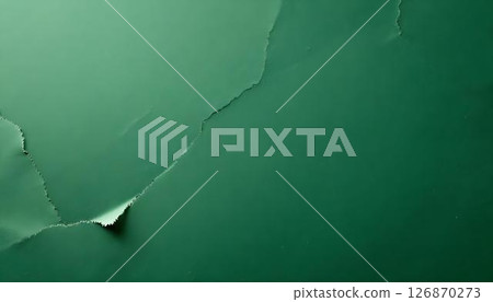 Close-up of a ripped green paper on a textured background, highlighting its detail and connection to Earth Day and recycling 126870273