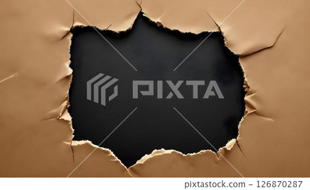 Jagged, torn paper with textured edges set against a black background, revealing intricate details and striking contrast 126870287