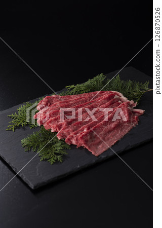 Image of thin slices of Japanese black beef lined up on granite 126870526