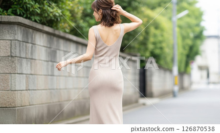 A Japanese woman walking through the city, looking back A Japanese woman walking through the city, looking back 126870538