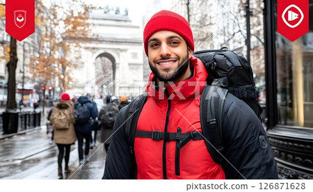 Smiling traveler with red beanie and backpack in front of Parisi 126871628