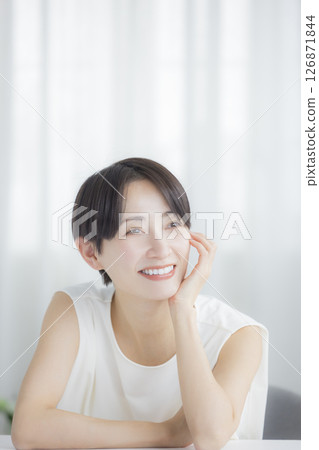 Middle-aged woman doing skin care in the living room 126871844