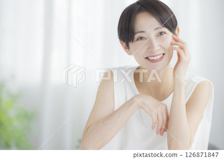 Middle-aged woman doing skin care in the living room 126871847