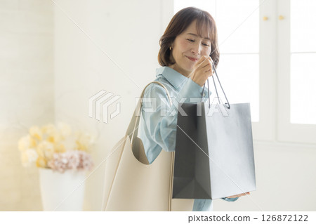 Middle-aged senior woman carrying a shopping bag Middle-aged senior woman carrying a shopping bag 126872122