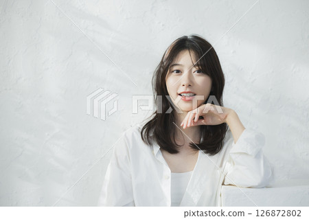 一位女士在白色牆壁前思考 126872802