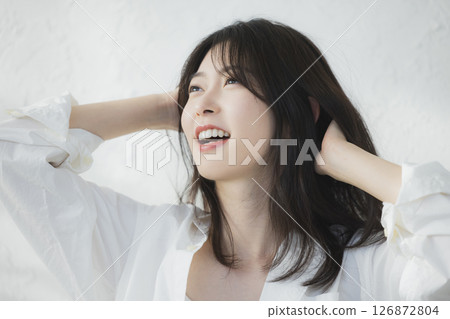 A woman thinking in front of a white wall 126872804