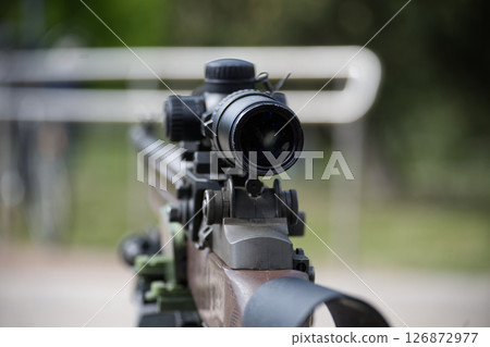 Close-Up Focused View of a Tactical Rifle Scope in Outdoor Environment Close-Up Focused View of a Tactical Rifle Scope in Outdoor Environment 126872977