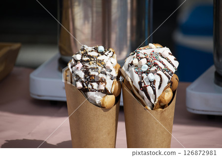 Delicious Bubble Waffles Topped With Whipped Cream and Colorful Sprinkles 126872981