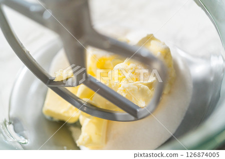 Close-up of a stand mixer creaming together butter and sugar for the Chocolate Ginger Sugar Cookie Dough, creating a light, fluffy base. 126874005