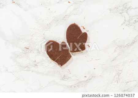 Overhead view of rolled-out Pale Gingerbread Cookie dough dusted with flour on a marble countertop, ready for shaping. Overhead view of rolled-out Pale Gingerbread Cookie dough dusted with flour on a marble countertop, ready for shaping. 126874037