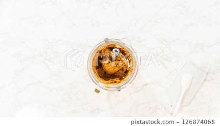 Overhead view of a mixing bowl containing fully blended Classic Gingerbread Cookie Dough. The dark, rich brown dough shows a smooth, dense texture, ready to be chilled before rolling and baking into 126874068
