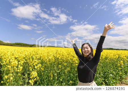 A woman sightseeing in a field of rapeseed flowers in full bloom 126874191