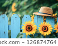 淺藍色的木柵欄、向日葵和草帽 126874764