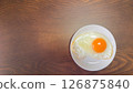A soft-boiled fried egg on a white plate 126875840