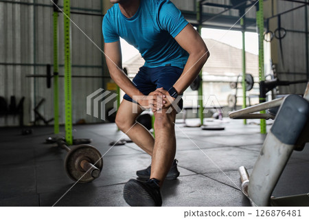 Fitness Stretching Routine. Young man warming up before workout in gym. Fitness Stretching Routine. Young man warming up before workout in gym. 126876481