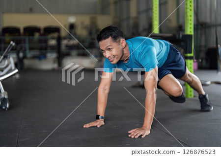 Fitness: Man Engaging in Push-Up Variation in Gym 126876523