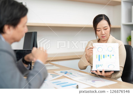 Data Analysis and Business Strategy. Professional presenting financial graphs in a meeting. 126876546