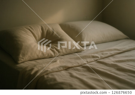 Cozy bed with pillows in warmly lit bedroom Cozy bed with pillows in warmly lit bedroom 126876650