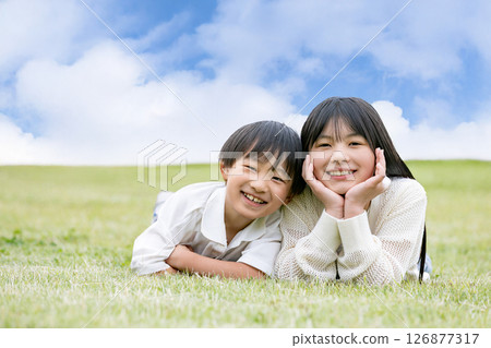 A child smiling and resting his chin on his hand 126877317