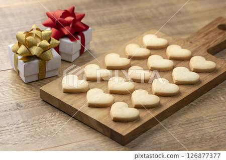 Handmade heart-shaped cookies lined up alongside gifts 126877377