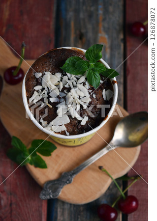 Chocolate mousse with shredded coconut topping and fresh mint served in rustic cup on wooden surface perfect for dessert menu designs sweet food advertisements and cozy cafe promotions Chocolate mousse with shredded coconut topping and fresh mint served in rustic cup on wooden surface perfect for dessert menu designs sweet food advertisements and cozy cafe promotions 126878072