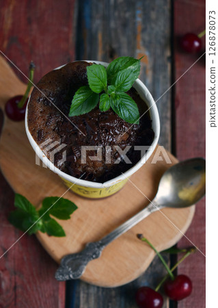Chocolate cake with fresh mint served in rustic coffee cup on vintage wooden background perfect for bakery advertisements dessert menus and rustic food styling concepts Chocolate cake with fresh mint served in rustic coffee cup on vintage wooden background perfect for bakery advertisements dessert menus and rustic food styling concepts 126878073