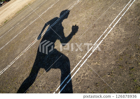 A figure running on a dirt track 126878936