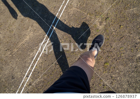 A figure running on a dirt track 126878937