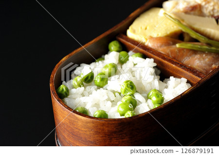 在黑色背景下拍攝的豆米便當盒，裡面有許多配菜 126879191