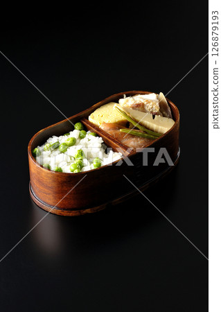 Bean and rice bento with plenty of side dishes photographed against a black background 126879193