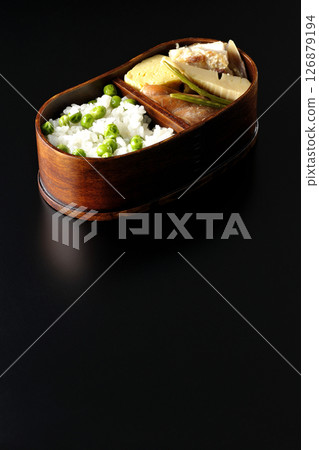 Bean and rice bento with plenty of side dishes photographed against a black background 126879194