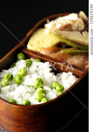 Bean and rice bento with plenty of side dishes photographed against a black background 126879199