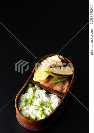 在黑色背景下拍攝的豆米便當盒，裡面有許多配菜 126879203