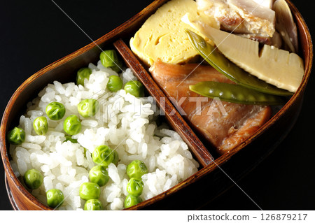 在黑色背景下拍攝的豆米便當盒，裡面有許多配菜 126879217